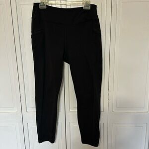 Lined black leggings with zip pockets and reflective stripe at ankle